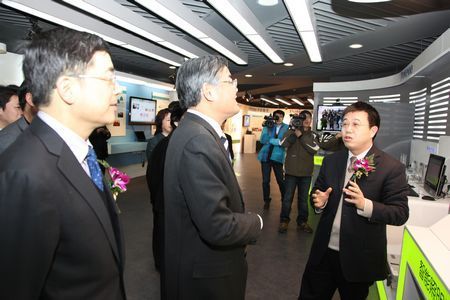 杭州市市长邵占维(中)在参观中国普天大厦，杭州鸿雁电器总裁王米成(右)进行讲解