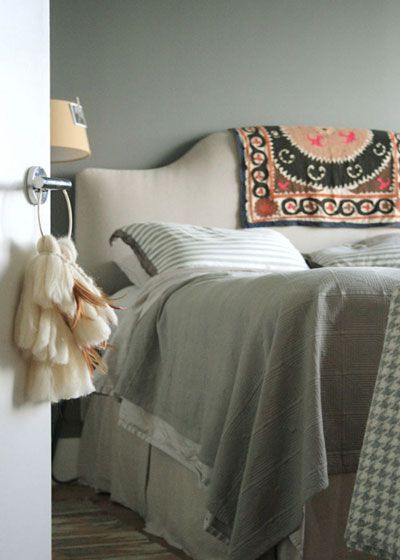 灰白相间的床上用具，给人清爽自然的温馨感。床头板上的图腾布艺为寝室装修增加了民族风的颜色层次