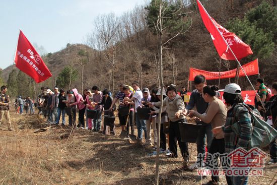 150人植树者排成队传水，在长城背景下，气势恢弘，自成风景