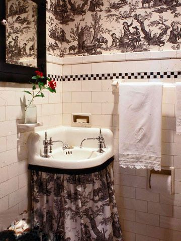 黑白两色棋盘格的腰线与壁纸花纹的风格相吻合，为普通的卫浴空间带来充满另类的奢华感