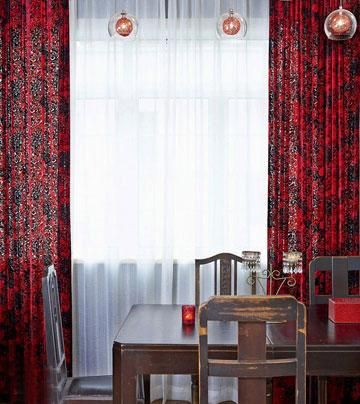 红色窗帘端庄稳重并有对称的美感，几个大小不一的玻璃吊灯却打破这种沉稳的布局