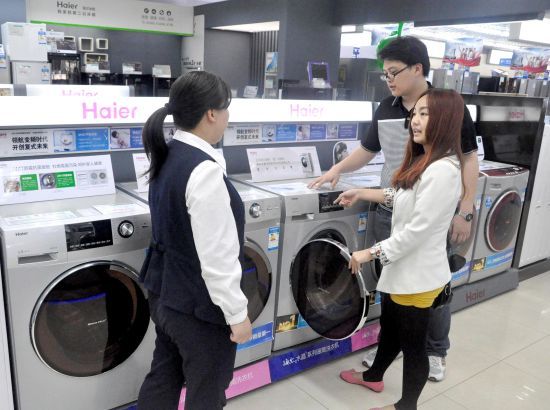 导购在向顾客介绍滚筒洗衣机的特点
