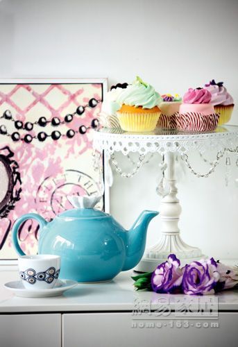 紫色的鲜花、精致的蛋糕托与温柔的瓷质茶壶，一幅温馨的下午茶图画就这样呈现在眼前