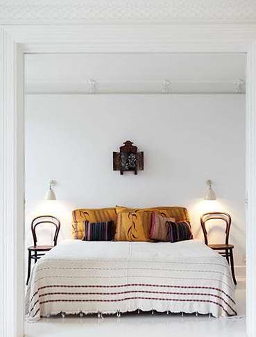 家具的原木色、地毯（装修效果图）的异域风，床品温柔质感和色调使白色不那么单调