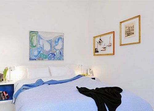 卧室以大面积的白色作为基调，同时蓝色的床品进行点睛，让整个空间沉浸在浪漫的气息里，带来淡雅、舒适的感觉。整体壁柜、睡床、床头柜等造型简洁，使空间不显繁冗