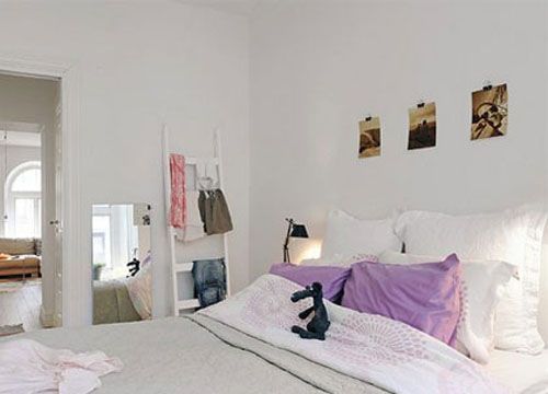 白色的天花板到白色的墙面，再到白色的家具，搭配上烟紫色的靠包和带有淡淡印花的床品，为洁净的纯白色空间加入一点浪漫的柔情。床边的木质楼梯 完善了卧室里的收纳功能