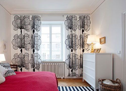 窗帘是黑白两色的大朵大朵的花案，和条纹的地毯靠包相配，即使是最简单的最没有情绪的两种无性向色彩，有了浪漫花朵图案的渲染，也让房间变得柔美起来