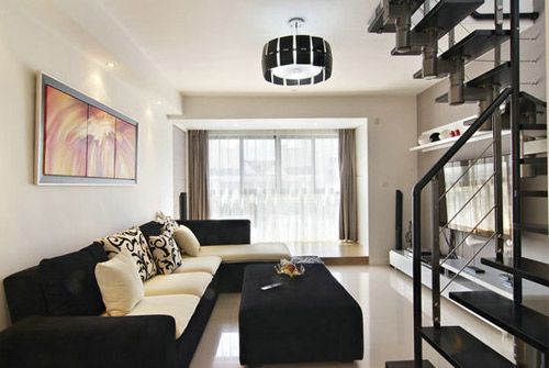 客厅的沙发是运用黑白两色的布艺沙发和茶几。这样尽显时尚的感觉。采用落地玻璃，使客厅的采光效果不错