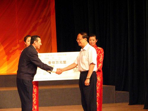 图为：蓝景丽家总经理尹勃(左)代表企业向灾区捐款100万