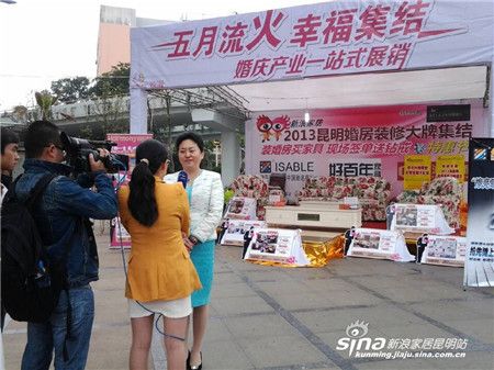 云南省婚庆行业协会会长在家居展台前接受媒体采访